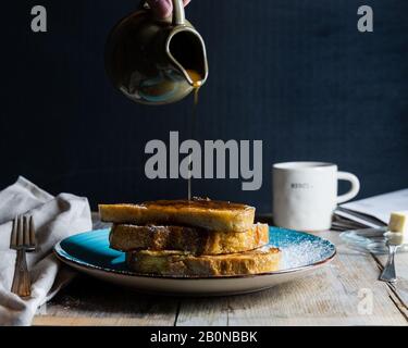 maple syrup being poured over french toast Stock Photo