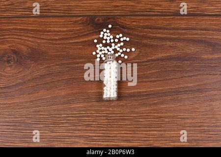 Bottle with homeopathic pills on wooden background. Stock Photo