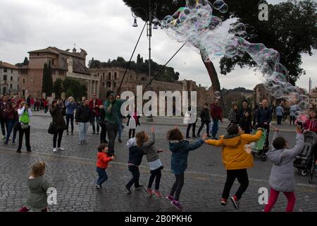 Children having fun with soap bubbles on the streets close to the Colosseum, Rome, Italy Stock Photo