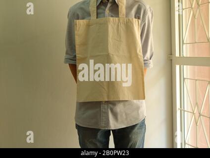 Closeup cotton cloth bag hanging on a person neck, climate change, plastic free concept Stock Photo