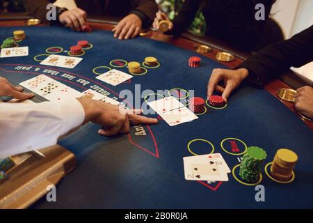 Croupier holds poker cards in his hands at a table in a casino. Stock Photo