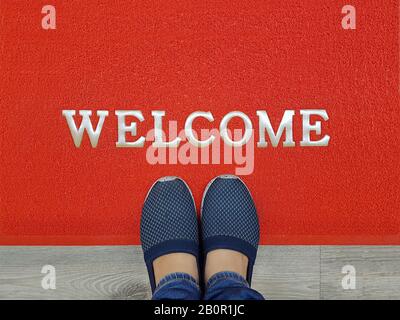 red welcome carpet with foot-ware on it Stock Photo