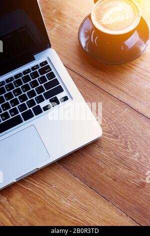 work space concept. laptop, top view of workplace with laptop on wood table with coffee cup with copy space for your text Stock Photo