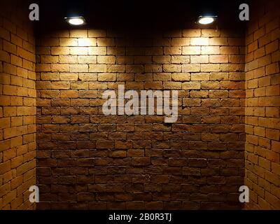abstract old brick wall in the dark with two spotlight, warm light tone. brick wall in empty room. brick wall background for wallpaper Stock Photo