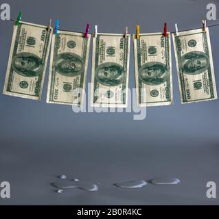 Launched money is dried on a rope. Concealment of taxes. Joke. Stock Photo