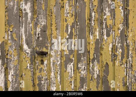 Texture of an old garage losing the yellow and green paint Stock Photo
