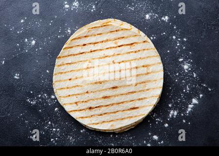 Grilled tortillas, flat breads on dark grey background. Copy space. Top view. Stock Photo
