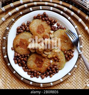 Close up of Vietnamese traditional food for Tet holidays, delicious fried glutinous rice cake on plate on wooden background for breakfast Stock Photo