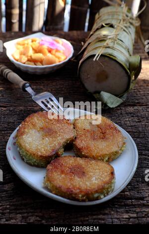 Close up of Vietnamese traditional food for Tet holidays, delicious fried glutinous rice cake on plate on wooden background for breakfast Stock Photo