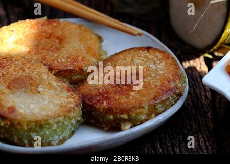 Close up of Vietnamese traditional food for Tet holidays, delicious fried glutinous rice cake on plate on wooden background for breakfast Stock Photo