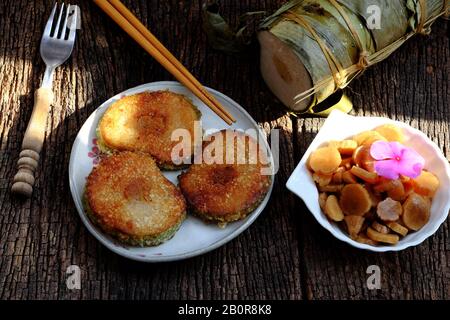 Close up of Vietnamese traditional food for Tet holidays, delicious fried glutinous rice cake on plate on wooden background for breakfast Stock Photo