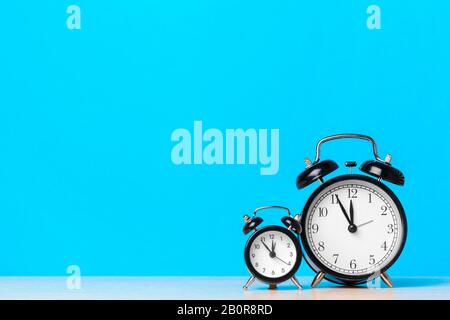 Different alarm clocks on table. Time change concept Stock Photo