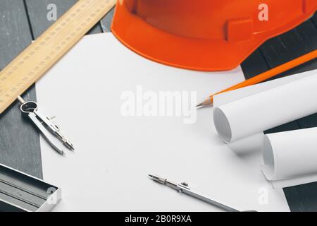 Engineer workplace with blueprints, compass, pencil and safety helmet. creative photo. Stock Photo
