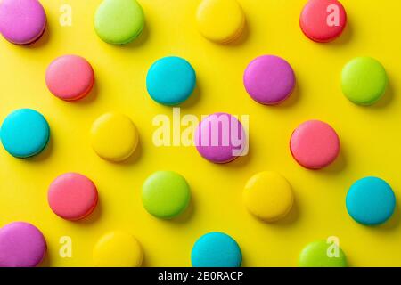 Macaroons dessert on yellow background. Flat lay composition. Top view. Stock Photo