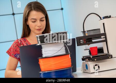 Young female designer works with a home 3D printer Stock Photo