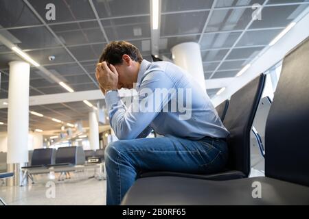 Flight Delay And Cancellation. Upset Man In Airport. Stock Photo