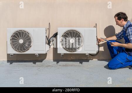 Man Doing Heating, Ventilation, And Air Conditioning Inspection Stock Photo