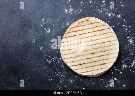 Grilled tortillas, flat breads on dark grey background. Copy space. Top view. Stock Photo