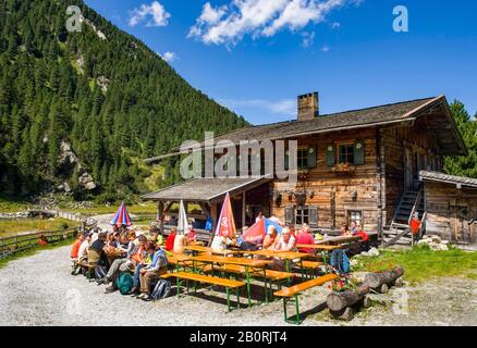 Managed alpine hut with hiker, Krimmler Achental, Krimmler Tauernhaus, Krimmler Ache, Krimml, Pinzgau, Land Salzburg, Austria Stock Photo