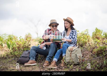 Young couple hikers  looking a map in the forest Stock Photo