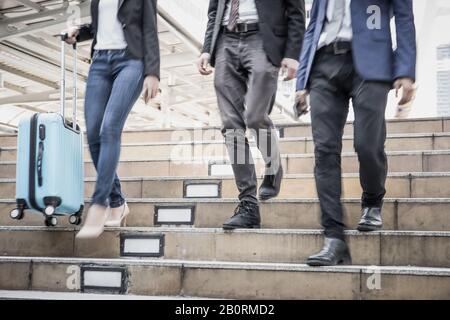 Business people walking down the stairs. On the way back from work quickly. Stock Photo