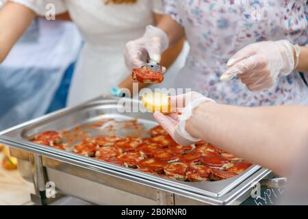 A process of mini hamburgers cooking with two people, buns and hamburger patties Stock Photo