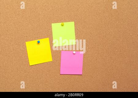 colorful sticky notes with pushpins and blank space, on cork background Stock Photo