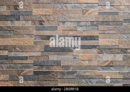 Background of stone wall made with blocks. New design of a modern wall as a background or texture. An example of masonry as an exterior wall cladding. Stock Photo