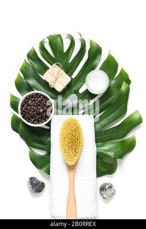 SPA set for cellulite removal, tough cacius brush, coffee beans, soap, towel, decorated monstera leaf, isolated on white. View from above. Vertical fo Stock Photo