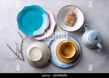 Ceramic crockery tableware, plates, bowls, cup and teapot on grey stone background. Top view. Stock Photo