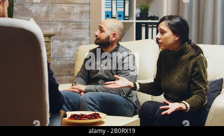Zoom in shot of angry young wife at couples therapy. Psychologist in couple difficulties. Stock Photo