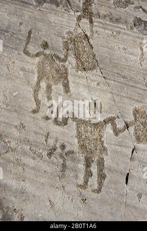 Petroglyph, rock carving, of two warriors holding swords and shields. Carved by the ancient Camuni people in the iron age between 1000-1600 BC. Rock n Stock Photo