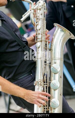 A silver saxophone musician closeup in instrumental playing on the city street Stock Photo