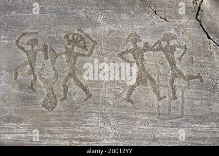 Petroglyph, rock carving, of two warriors boxing and two warriors fighting with swords and small shields, one is wearing a headress. Carved by the anc Stock Photo