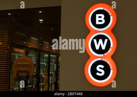 Brisbane, Queensland, Australia - 26th January 2020 : Illuminated BWS (Beer - Wine - Spirits) sign hanging in front of a store entrance in Brisbane. B Stock Photo