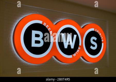 Brisbane, Queensland, Australia - 26th January 2020 : Illuminated BWS (Beer - Wine - Spirits) sign hanging in front of a store entrance in Brisbane. B Stock Photo