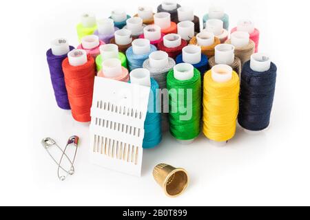 Tailor needles and threads over white. Stock Photo