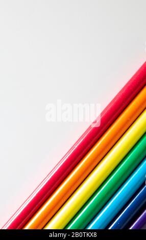 Colored pencils arranged in diagonal pattern on white background Stock Photo