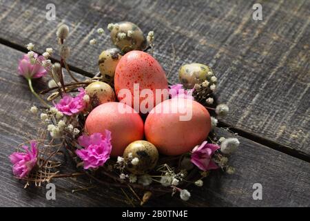 Easter eggs on wooden background. Pink  handmade easter eggs in a basket. Copy space. Stock Photo