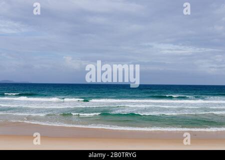 Summer sea sunset on the cave beach, the sun, waves and clouds, beautiful dramatic lighting, sun behind Stock Photo