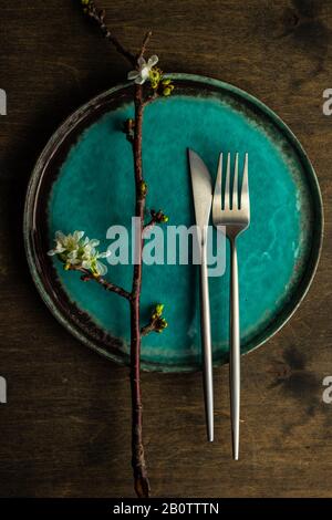Spring table setting with cutlery and blooming cherry branch on rustic background with copy space Stock Photo