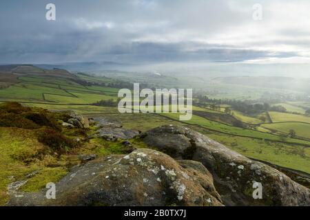 Rainy day, scenic rural high view from Embsay Crag (misty rain clouds over valley, green fields, rolling upland hills) - North Yorkshire, England, UK. Stock Photo