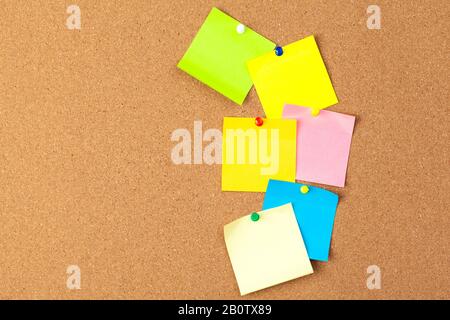 Cork board with several colorful blank notes with pins Stock Photo