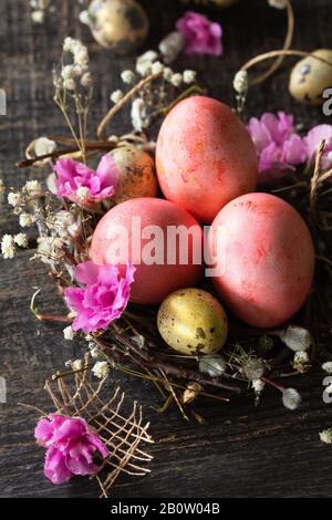 Easter eggs close-up on wooden background. Pink  handmade easter eggs in a basket. Stock Photo
