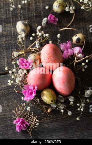 Easter eggs on wooden background. Pink  handmade easter eggs in a basket. Stock Photo