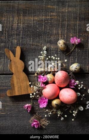 Easter eggs on wooden background. Pink  handmade easter eggs in a basket. Top view flat lay background. Copy space. Stock Photo