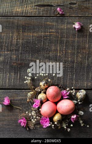 Easter eggs on wooden background. Pink  handmade easter eggs in a basket. Top view flat lay background. Copy space. Stock Photo