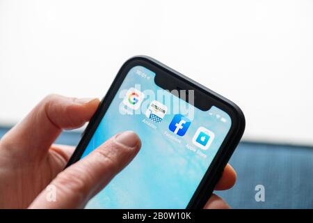 Paris, France - February, 20, 2020 : Mobile phone displaying the Gafa site in a woman's hand  : GAFA apps and icons on an iPhone. Google, Amazon, Face Stock Photo