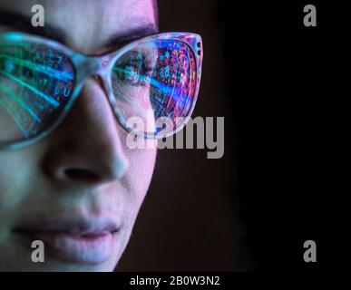 Electronic circuit board on computer monitor reflecting in glasses of a female engineer. Stock Photo