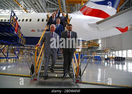 The Prince of Wales and British Airways CEO Alex Cruz walk down the steps after being shown around a Boeing 787-9 Dreamliner during a visit to the British Airways Maintenance Centre at Cardiff Airport, Wales, celebrating the company's 100th anniversary. Stock Photo